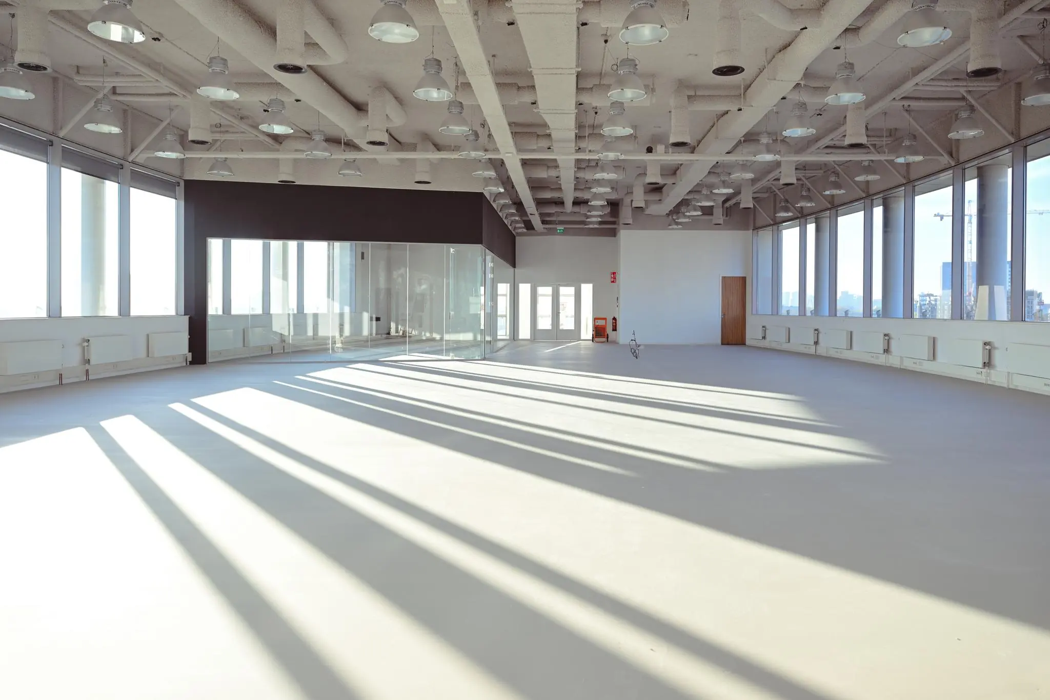 Licht en ruim leeg kantoorinterieur in Rivium Quadrant met grote ramen en industriële plafondafwerking.